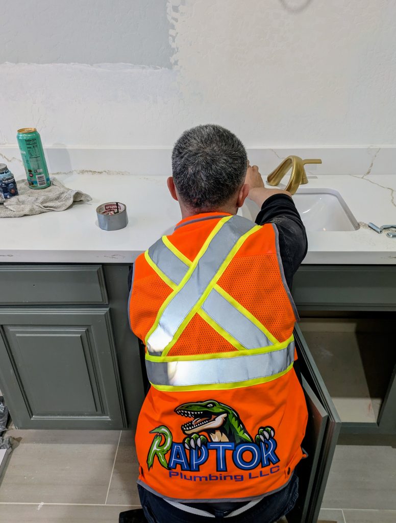 Raptor Plumbing technician installing a bathroom faucet